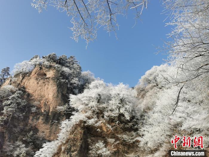 圖為藍(lán)天下霧凇籠罩山脈?！⌒煺袢A 攝