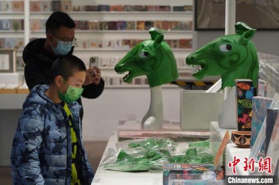 圖為“神馬來了”銅奔馬頭套吸引參觀者駐足?！【琶赖┰?攝