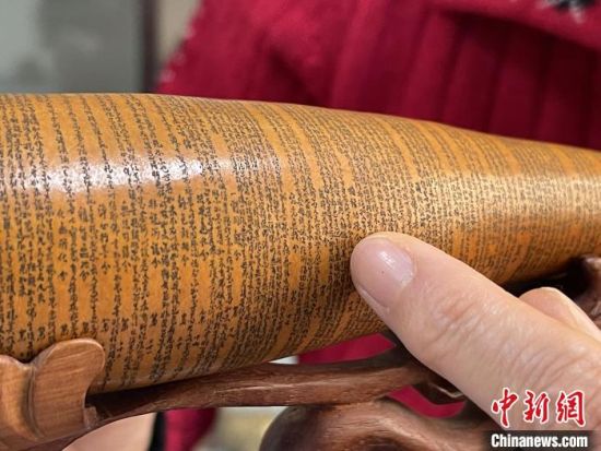 圖為長約二十公分的長條葫蘆雕刻佛教經(jīng)文作品。　張婧 攝