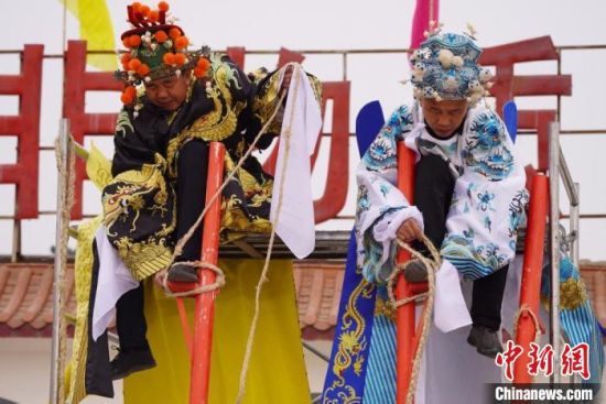 圖為“苦水高高蹺”表演者通過(guò)麻繩將腳固定在腳踏板，并在腿部纏繞六七圈?！【琶赖┰?攝