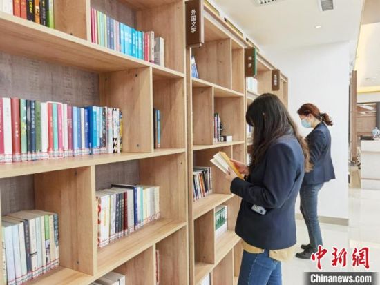 圖為在甘肅公航旅建設(shè)集團有限公司的職工書屋，職工挑選書籍?！⌒煅?攝