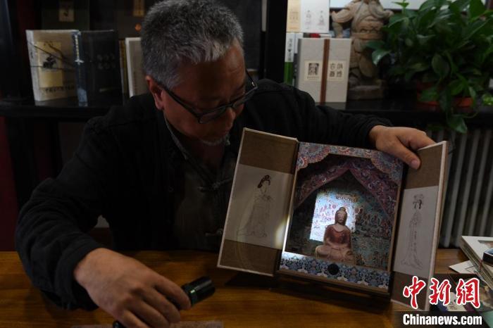 圖為讀者出版集團讀者晉林工作室獨立出品人徐晉林，展示互動性強的敦煌題材手工書。(資料圖) 楊艷敏 攝