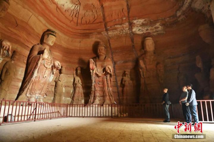 7月15日，游人參觀甘肅省平?jīng)鍪袥艽h百里石窟長廊中的南石窟寺1號窟。百里石窟長廊位于涇川縣境內(nèi)，由512個石窟、5眼窟中石井組成，現(xiàn)存王母宮石窟、鳳凰山石窟、南石窟寺、丈八寺石窟、羅漢洞石窟、太山寺石窟等規(guī)模較大的石窟群，還有數(shù)量眾多的小石窟群。南石窟寺開鑿于北魏永平三年，其中1號窟屬于大型七佛窟，七佛高達6米。中新社記者 李亞龍 攝