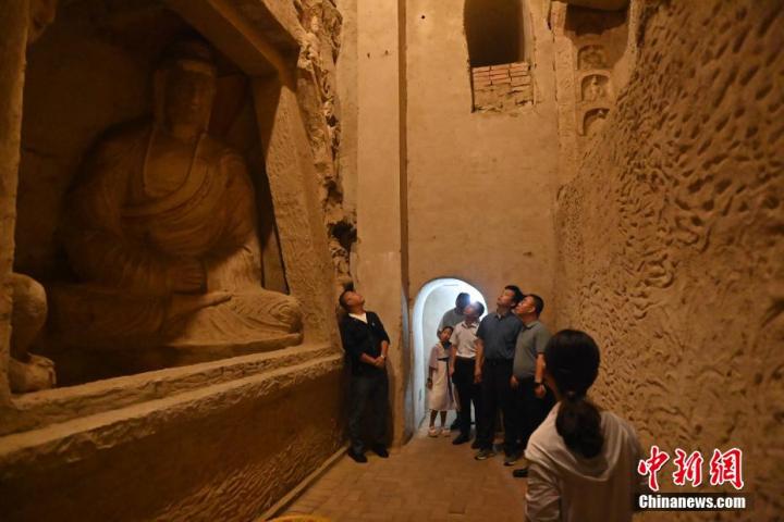 7月15日，游人參觀甘肅省平?jīng)鍪袥艽h百里石窟長廊中的王母宮石窟。百里石窟長廊位于涇川縣境內(nèi)，由512個石窟、5眼窟中石井組成，現(xiàn)存王母宮石窟、鳳凰山石窟、南石窟寺、丈八寺石窟、羅漢洞石窟、太山寺石窟等規(guī)模較大的石窟群，還有數(shù)量眾多的小石窟群。王母宮石窟又名千佛洞，該窟設(shè)計宏大，造像生動，窟內(nèi)擁有造像數(shù)百尊，是較為珍貴的佛教文化歷史遺存。中新社記者 李亞龍 攝</p>
<p>