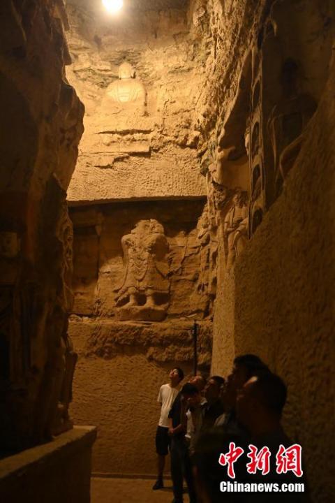 7月15日，游人參觀甘肅省平?jīng)鍪袥艽h百里石窟長廊中的王母宮石窟。百里石窟長廊位于涇川縣境內(nèi)，由512個石窟、5眼窟中石井組成，現(xiàn)存王母宮石窟、鳳凰山石窟、南石窟寺、丈八寺石窟、羅漢洞石窟、太山寺石窟等規(guī)模較大的石窟群，還有數(shù)量眾多的小石窟群。王母宮石窟又名千佛洞，該窟設(shè)計宏大，造像生動，窟內(nèi)擁有造像數(shù)百尊，是較為珍貴的佛教文化遺存。中新社記者 李亞龍 攝</p>
<p>